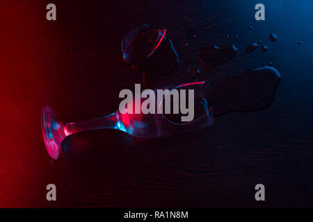 Un verre se briser sur le sol. neon light Banque D'Images
