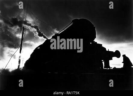 Août 1968, le dernier mois de fer à vapeur en Grande-Bretagne. Carnforth, Lancashire, près de Lancaster. Un pilote de moteur à monter les pistes pour lancer un tour de retard, la conduite d'un train de nuit. Banque D'Images