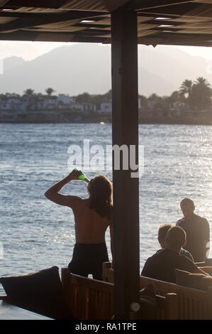 Se détendre avec un plongeur bière après une journée de plongée, Dahab, Egypte Banque D'Images