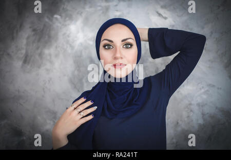 Belle jeune femme arabe en vêtements traditionnels en studio sur fond gris. Banque D'Images