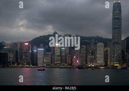 Le rouge vif élan de la Duk Ling'junk accents les lumières des gratte-ciel qui bordent le port de Hong Kong. Banque D'Images