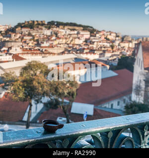 Ginja de Obidos, liqueur de cerises aigres, traditionnel, servi dans de petites tasses faites de chocolat avec arrière-plan panoramique de Lisbonne Banque D'Images