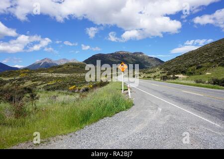 Noir et jaune Route glissante signer dans le pittoresque paysage alpin de l'île Sud de la Nouvelle-Zélande Banque D'Images
