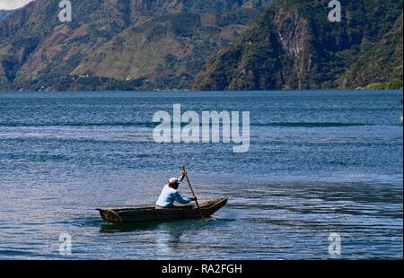 Un homme dans un canot en bois sur le lac Atitlan aller à la pêche Banque D'Images