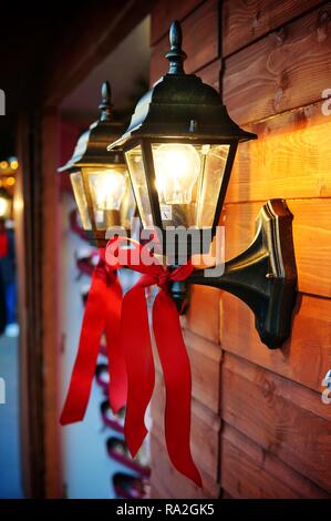 Une décoration de lampe murale vintage avec un ruban rouge, sur un marché de Noël. Banque D'Images