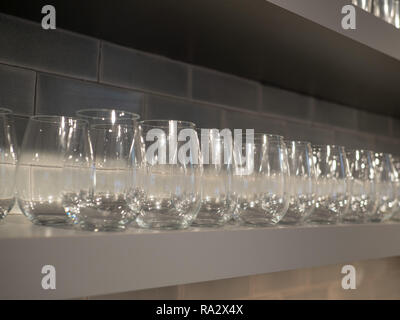 Étagère avec plusieurs rangées de petits verres de vin dans la cuisine Banque D'Images