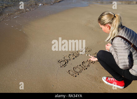 Palma, Espagne. 31 Dec, 2018. Kristine de Berlin écrire nouvelle année messages dans le sable de plage à Palma Molinar durant la matinée ensoleillée du dernier jour de l'année. Credit : Clara Margais/dpa/Alamy Live News Banque D'Images