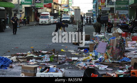 Cotabato City, Philippines. 31 Dec, 2018. Les policiers de recueillir des preuves des débris après un attentat au centre commercial à Cotabato City, Philippines, le 31 décembre 2018. Au moins deux personnes ont été tuées et 21 autres blessées, dont une fillette de quatre ans, lorsqu'un engin explosif improvisé (IED) a explosé le lundi après-midi près de l'entrée d'un centre commercial à Cotabato City, dans le sud des Philippines. Credit : Stringer/Xinhua/Alamy Live News Banque D'Images