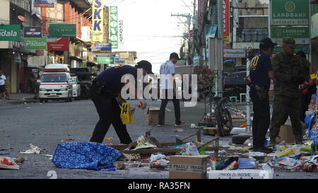 Cotabato City, Philippines. 31 Dec, 2018. Les policiers de recueillir des preuves des débris après un attentat au centre commercial à Cotabato City, Philippines, le 31 décembre 2018. Au moins deux personnes ont été tuées et 21 autres blessées, dont une fillette de quatre ans, lorsqu'un engin explosif improvisé (IED) a explosé le lundi après-midi près de l'entrée d'un centre commercial à Cotabato City, dans le sud des Philippines. Credit : Stringer/Xinhua/Alamy Live News Banque D'Images