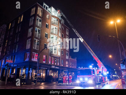Hambourg, Allemagne. 31 Dec, 2018. Les camions de pompiers sont garées en face d'un immeuble résidentiel dans le quartier Eimsbüttel. Après l'incendie de l'escalier, plus de dix personnes ont dû être prises à l'extérieur à l'aide d'une échelle. Crédit : Daniel Bockwoldt/dpa/Alamy Live News Banque D'Images