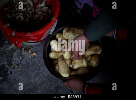 (190101) -- JULIAN, JAN. 1, 2019 (Xinhua) -- Les filles place des pommes pelées pour la cuisson à l'heure du déjeuner à Haoba central school dans le comté de Junlian de Yibin City dans le sud-ouest de la province chinoise du Sichuan, le 8 décembre 2018. L'hébergement des étudiants, les joueurs ont à cuisiner pour eux-mêmes pendant les week-ends. Situé dans le sud-ouest des montagnes de Wumeng vaste la province chinoise du Sichuan, Haoba central school est une école de neuf ans fournissant l'enseignement primaire et secondaire l'éducation, tout comme les autres écoles dans cette zone montagneuse. Cependant, une équipe de basket-ball créée par les étudiantes a fait l'école assez célèbre dans Banque D'Images