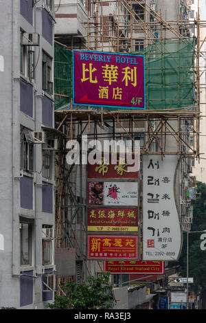 Les panneaux publicitaires et les échafaudages en bambou en concurrence pour l'espace sur les bâtiments de Lockhart Road à Hong Kong, le quartier de Wan Chai Banque D'Images