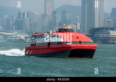 L'hydrofoil catamaran turboréacteur 'Penha' Navigation dans le port de Victoria en route vers Macao, avec les gratte-ciel du quartier de Wan Chai à l'arrière-plan Banque D'Images