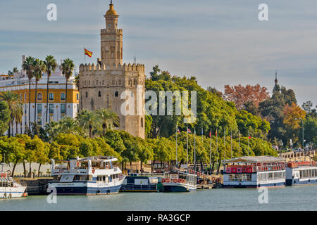 Séville espagne LA TOUR DE L'OR SUR LES RIVES DE LA RIVIÈRE GUADALQUIVIR ET LES TOURISTES OU VOYAGEURS AMARRÉS BATEAUX SUR L'EAU Banque D'Images