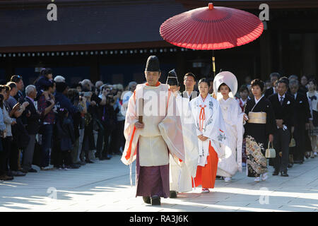 Mariage Shinto procession avec mariée de porter le watabōshi capot blanc traditionnel à marcher avec le marié dans le Sanctuaire Shinto de Meiji Jingu Banque D'Images