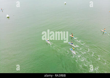 Des hommes forts flottant sur un SUP boards dans une magnifique baie sur une journée ensoleillée. Vue aérienne de l'homme traverse la baie en utilisant le paddleboard. Sports d'eau, des concours Banque D'Images