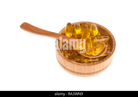 Vitamine jaune capsules de gélatine molles avec des médicaments huileux et supplément nutritionnel, cuillères en bois, scoop. Studio Photo Banque D'Images