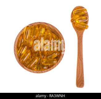 Vitamine jaune capsules de gélatine molles avec des médicaments huileux et supplément nutritionnel, cuillères en bois, scoop. Studio Photo Banque D'Images