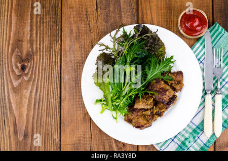 Tranches de foie poêlé, vert feuilles de salades. Studio Photo Banque D'Images