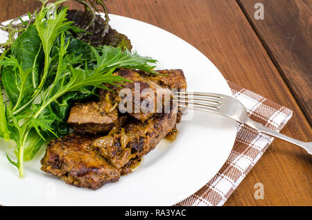 Tranches de foie poêlé, vert feuilles de salades. Studio Photo Banque D'Images