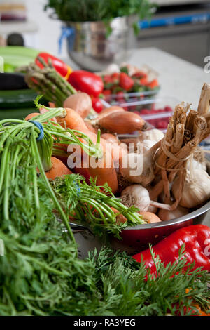 Des ingrédients frais de préparation des légumes dans une cuisine avec les carottes, l'ail, le gingembre et les poivrons Banque D'Images