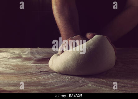 Chef boulanger préparer la pâte à pain dans une boulangerie. Cuisine professionnelle. Banque D'Images