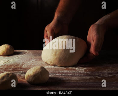 Chef boulanger préparer la pâte à pain dans une boulangerie. Cuisine professionnelle. Banque D'Images