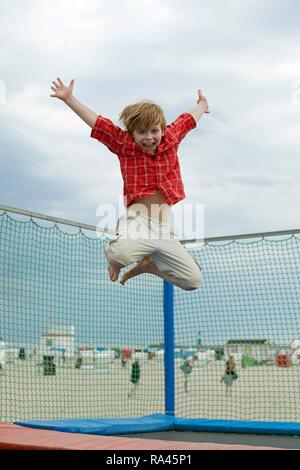 Garçon sautant sur un trampoline, de Warnemunde, Rostock, Mecklembourg-Poméranie-Occidentale, Allemagne Banque D'Images