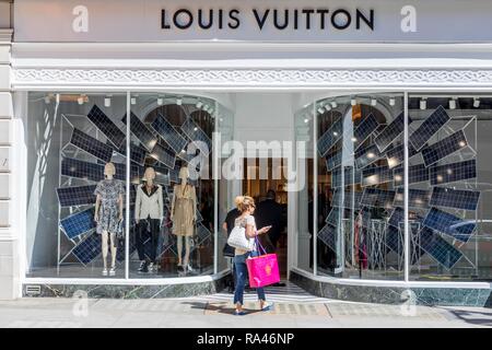 Les passants devant la vitrine du magasin de mode Louis Vuitton, Londres, Royaume-Uni Banque D'Images