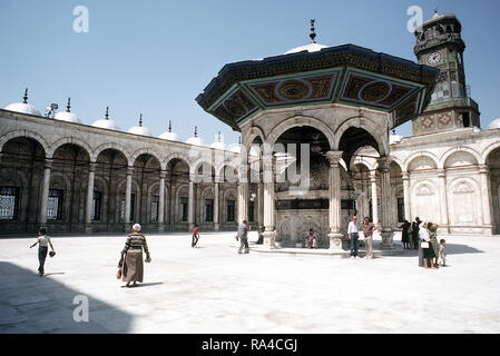 Fontaine d'ablution dans le centre de la cour intérieure de la mosquée de Mohammed Ali Caire le haut de la Citadelle du Caire, avec tour de l'horloge de Napoléon III en arrière-plan. ca. 1983 Banque D'Images