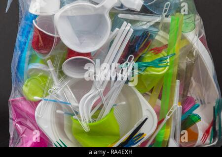 Sac poubelle rempli de vaisselle jetable en plastique, couverts, vaisselle en plastique, plastique, verres en plastique, des sacs en plastique et d'autres Banque D'Images