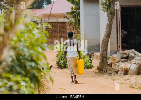 Femme transportant de l'eau à Entebbe, Ouganda Banque D'Images