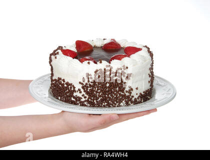 Mains tenant glaçage à gâteau au chocolat avec crème vanille en lustre de chocolat topping entouré par des fraises trempées dans le chocolat glaçage chi Banque D'Images