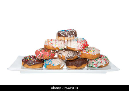 Plaque rectangulaire avec gâteau givré donuts empilés, couverts de candy sprinkles dans diverses couleurs, isolé sur blanc. Banque D'Images