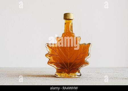Le sirop d'érable dans une bouteille en forme de feuille Banque D'Images