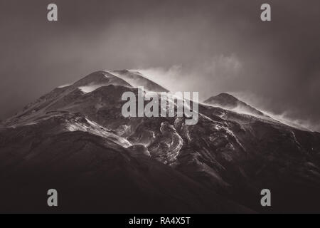 Vent qui souffle la neige de sommets de montagnes, sombre paysage pittoresque vu de l'angle faible, édité avec effet sépia Banque D'Images