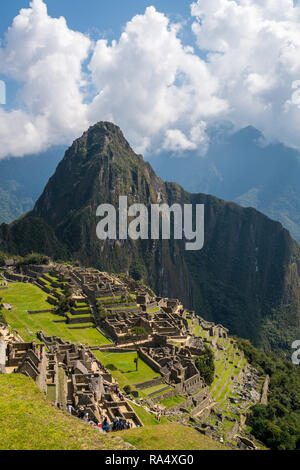 Vue aérienne de l'ancienne cité inca de Machu Picchu, avec la montagne Huayna Picchu raide et l'herbe vert vif Banque D'Images