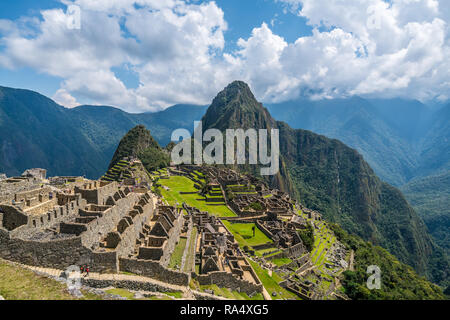 Vue pittoresque de célèbres ruines de l'ancienne cité inca de Machu Picchu au Pérou, avec l'herbe vert vif et raide Huayna Picchu montagne en arrière-plan Banque D'Images