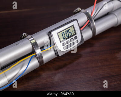 Bombe tuyau avec un écran LCD horloge pour déclencher la détonation, sur table en bois Banque D'Images