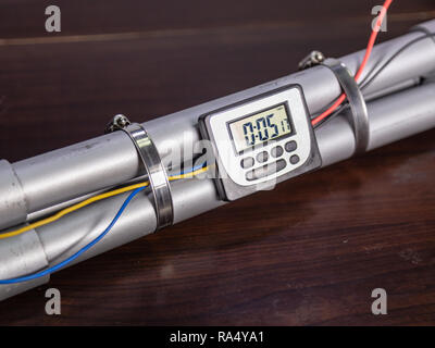 Bombe tuyau avec un écran LCD horloge pour déclencher la détonation, sur table en bois Banque D'Images