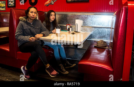 Les jeunes Américains d'origine et sa mère Caroline du Beach diner sitting at table Banque D'Images