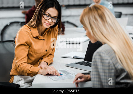 Focus sélectif des jeunes businesswomen doing paperwork in office Banque D'Images