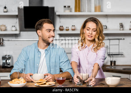 Smiling woman Pretty woman putting verres sur table de cuisine Banque D'Images