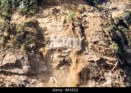 Travaux de construction de routes de terre et de gravats d'envoi vers le bas d'une colline, dans l'Himalaya au Népal Banque D'Images