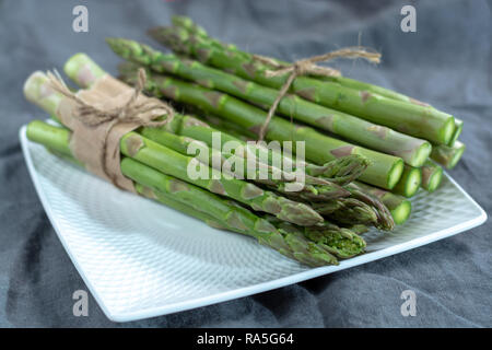 Matières premières fraîches légumes asperges vertes sur tableau blanc, Close up Banque D'Images