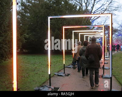 Les visiteurs marchent à travers un tunnel de lumière, pas encore au crépuscule, sur le sentier de la lumière de Noël dans le parc à Waddesdon Manor, Noël 2018 Banque D'Images