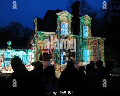 La silhouette de l'auditoire dans le noir, regardant les illuminations festives projetée sur les murs de l'étable à Waddesdon Manor, Noël 2018 Banque D'Images