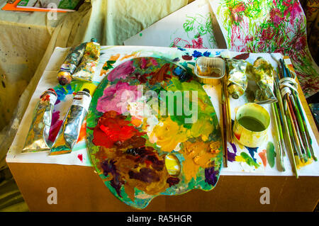 Un petit banc dans un studio d'artiste avec les éléments nécessaires à la peinture à la main. Banque D'Images