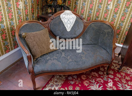 Table ancienne avec napperon, oreiller de jet, rose et bleu vintage papier peint floral & tapis. L'intérieur de la vieille maison, Chestnut Square, McKinney au Texas. Banque D'Images