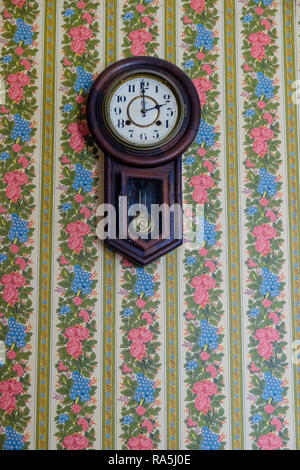 Horloge murale pendule Antique & blue & pink vintage papier peint floral. Intérieur de l'ancien accueil Texan, Chestnut Square Historic Village, McKinney au Texas. Banque D'Images